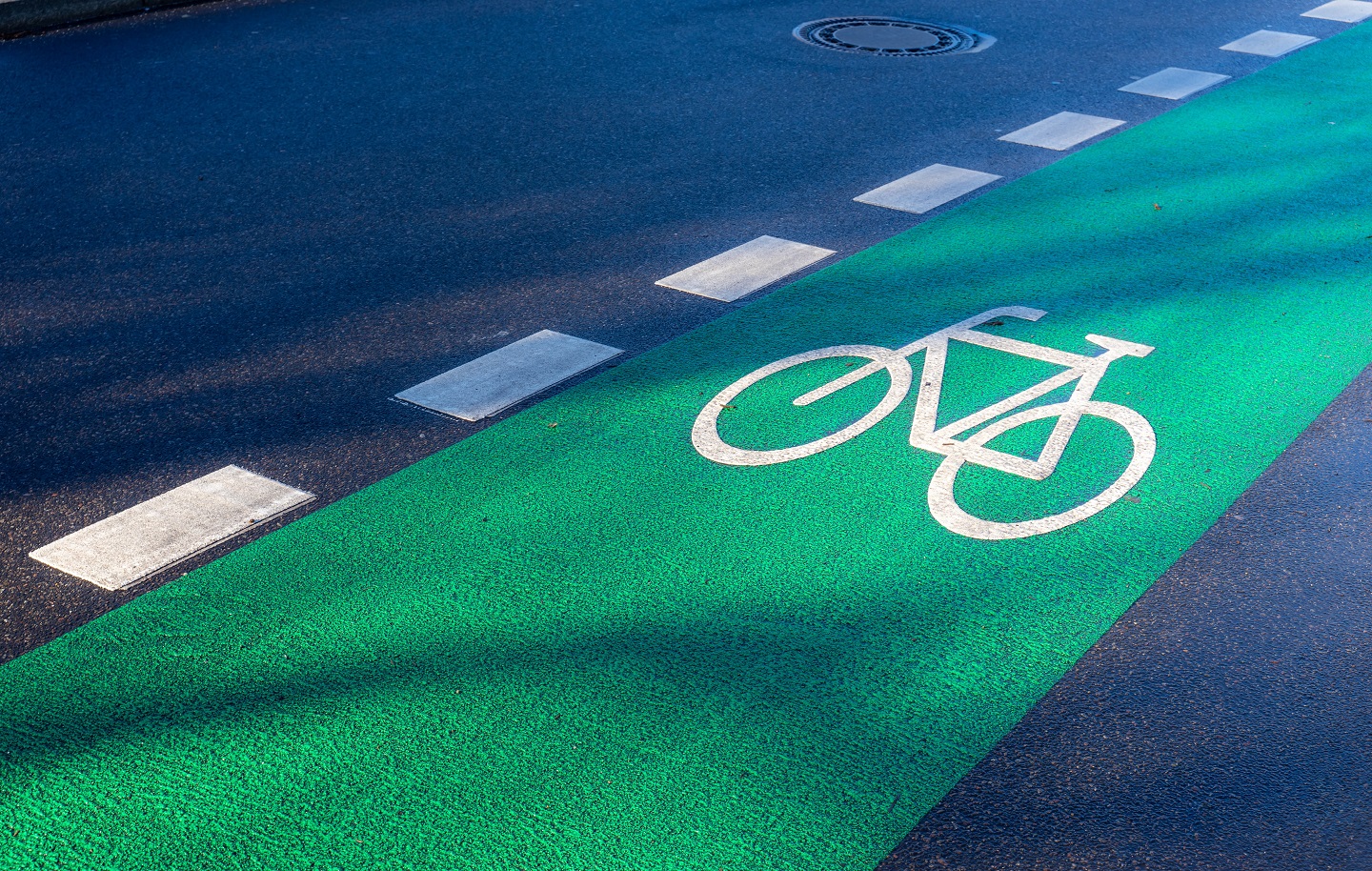 Zu sehen ist ein in grün eingezeichneter Fahrradweg auf einer Straße